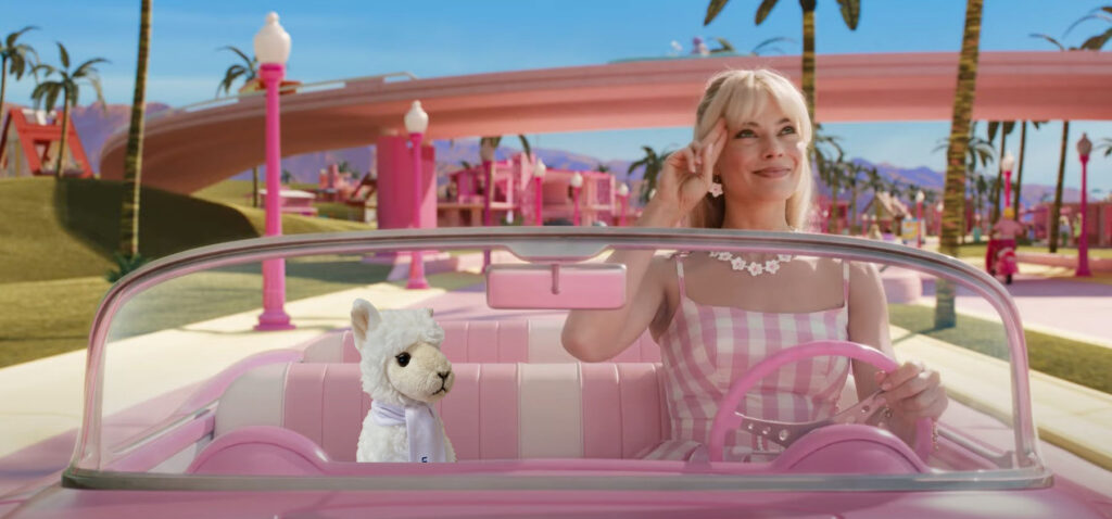 Stuffed llama toy with Barbie from the movie 'Barbie' in Barbie's car