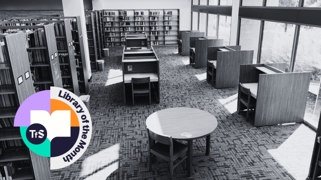 Black and white photo of inside of a library with Library of the Month logo