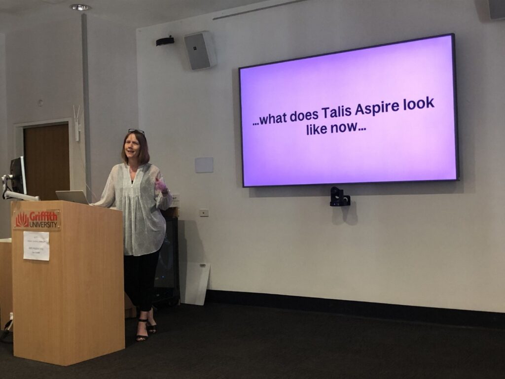 Photograph of Nicola at Technology from Sage delivering a presentation at Insight APAC conference. The text on screen says "What does Talis Aspire look like now.."